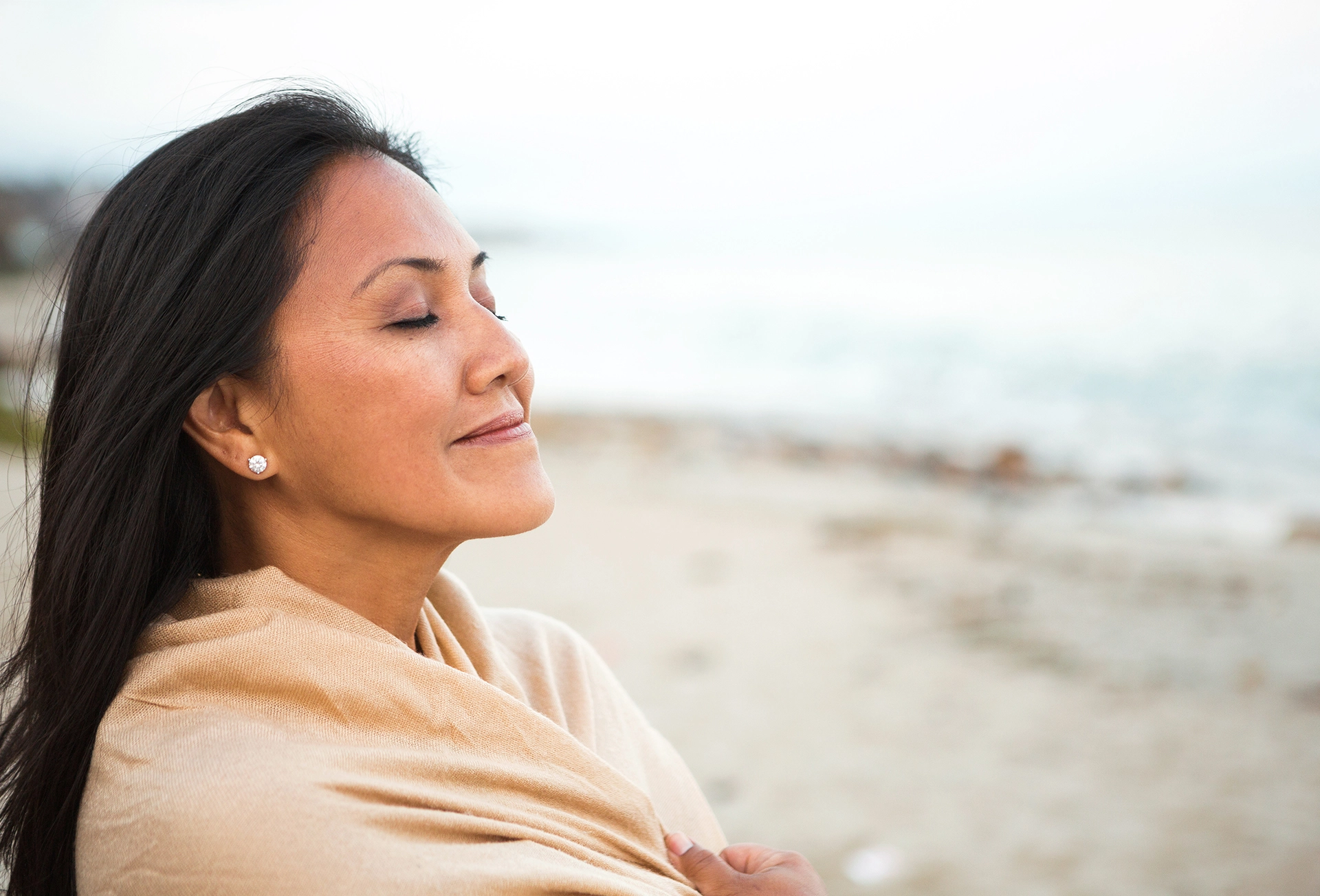 Woman in a blanket on the beach