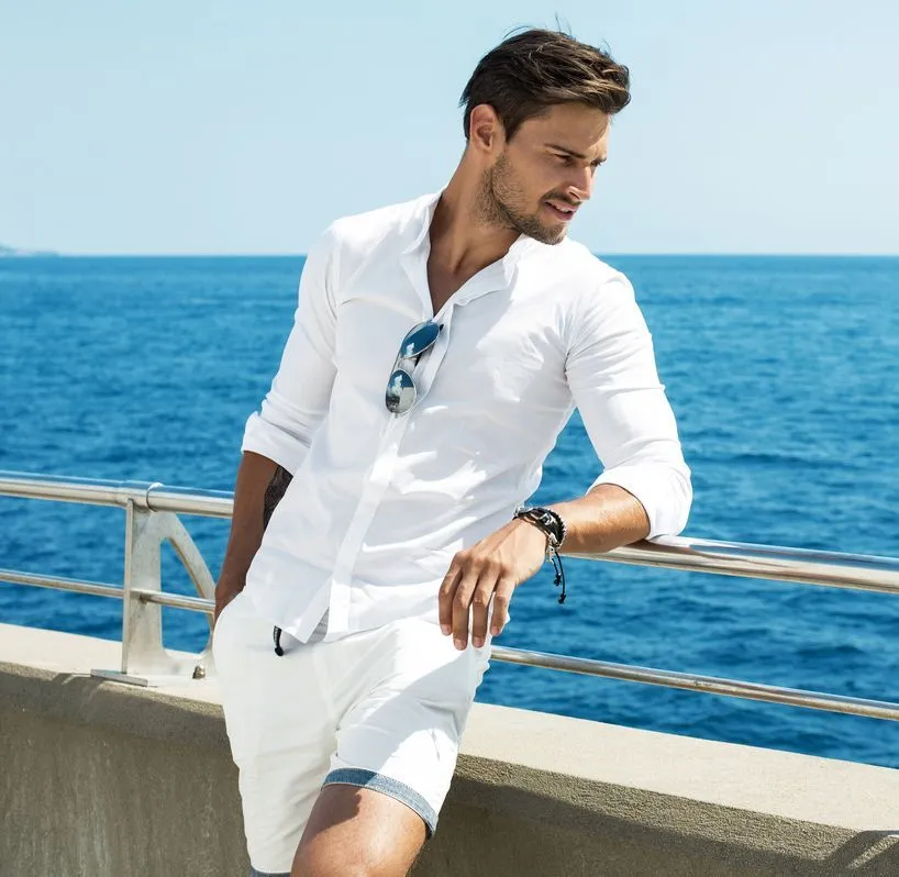 Man leaning on railing by ocean
